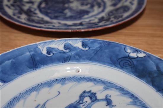 An 18th century Kangxi Chinese blue and white dragon plate and one other. largest diameter 22.5cm